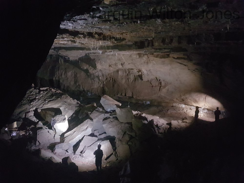 At the feet of the caver on the left